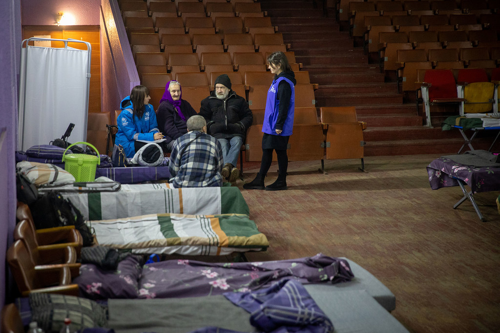 Сотрудники УВКБ разговаривают с переселенцами из Донецкой области в транзитном центре.